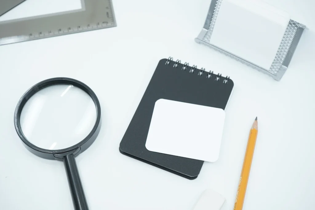 Magnifying glass on a desk, representing the question: are NDIS plan managers registered?