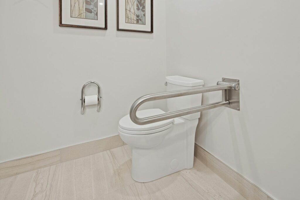 A stainless steel grab rail fitted beside a toilet, an example of NDIS assistive technology