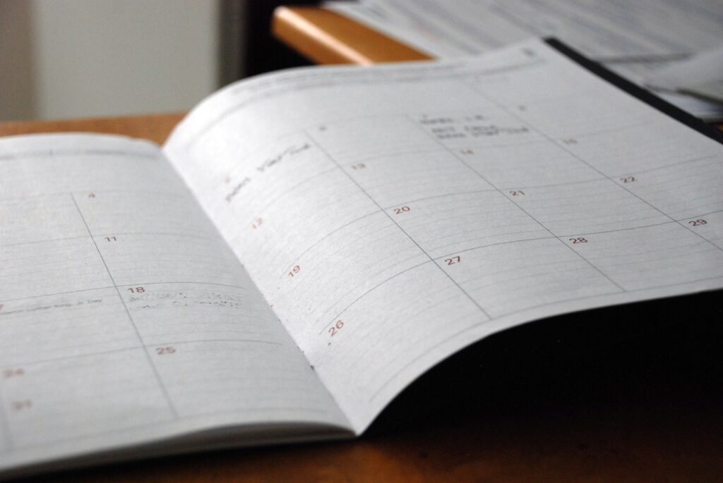Open monthly planner on a desk, representing NDIS plan reassessment dates