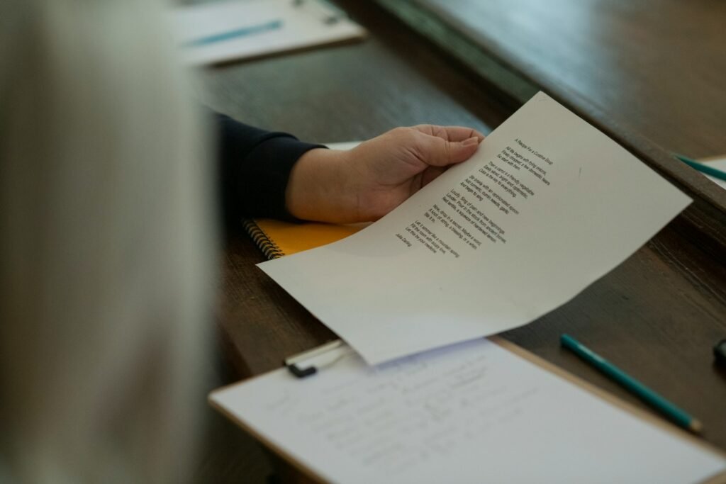 A person reading a printed document at a desk, representing an NDIS plan booklet